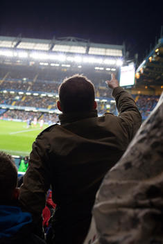 A Chelsea supporter pointing at the pitch at Stamford Bridge during a Chelsea vs. Stoke City FA Cup match
