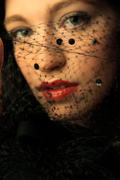 Woman Hides Behind A Black Netted Veil