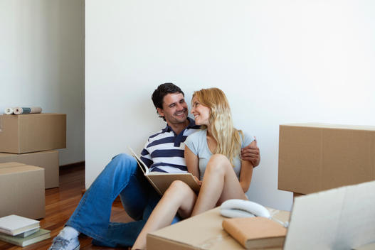 Couple unpacking cardboard boxes in new house