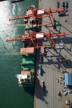 Aerial view of cranes unloading container ship at commercial dock