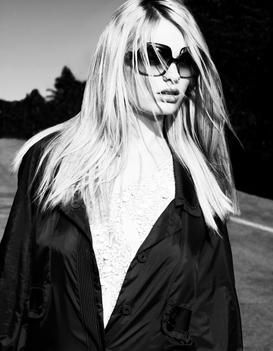 A Black And White Portrait Of A Model Wearing Large Oversized Sunglasses.