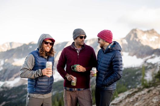 lifestyle shot of guys hanging out drinking beers in the mountains