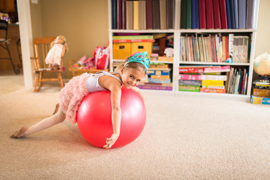 Portrait of cute young girl on top of exercise ball
