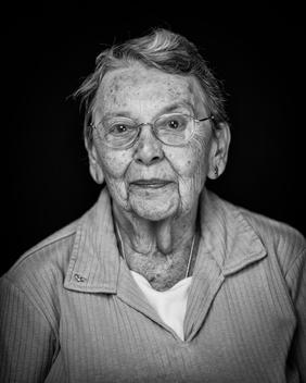 Black and white portrait of elderly woman wearing glasses slight smile