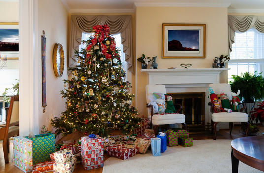 A formal living room with Christmas tree and gifts