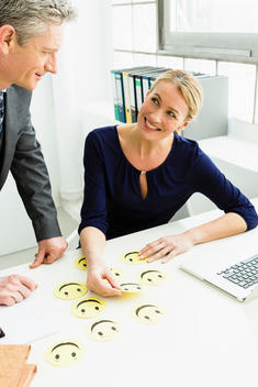 Germany, Businesspeople with anthropomorphic face in office, smiling