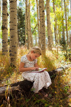 Caucasian girl using digital tablet in woods
