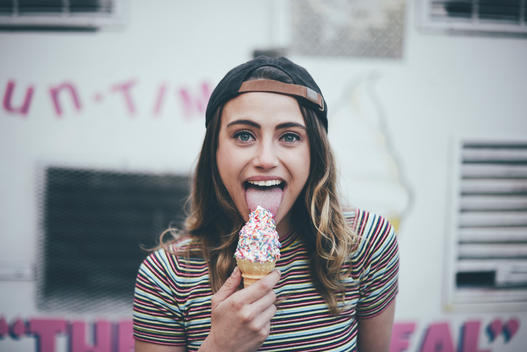 Girl in front of ice cream truck licking it