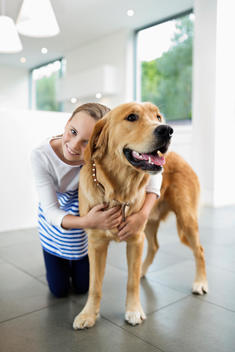 Girl hugging dog indoors