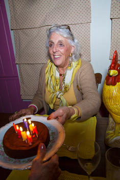 Senior woman celebrates her birthday with cake.