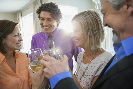 Happy family and friends toasting wine at home party
