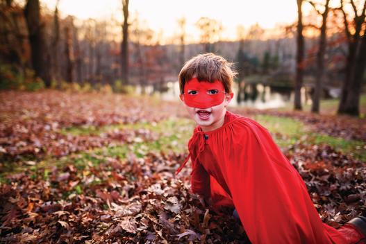 Young boy playing with red super hero mask