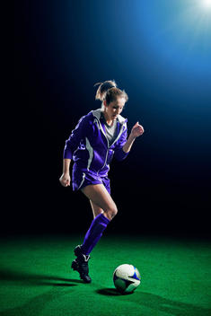 Female soccer player running with ball