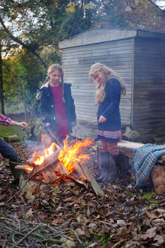 Girls building bonfire outdoors