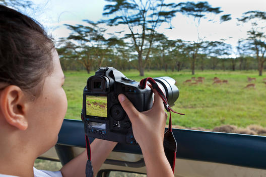 Africa,Kenya, Teenage girl taking picture of animal in Lake Nakuru National Park