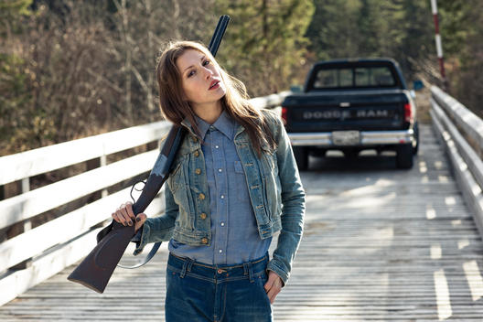girl with gun and pickup truck on bridge