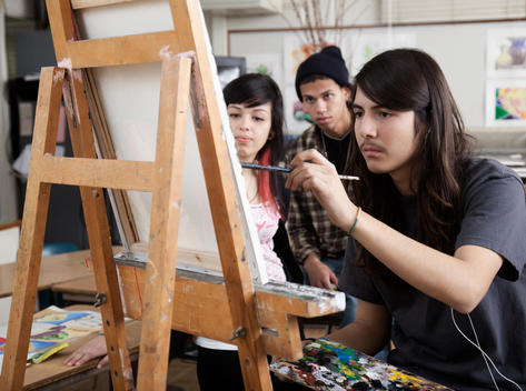 Hispanic artist painting in art class
