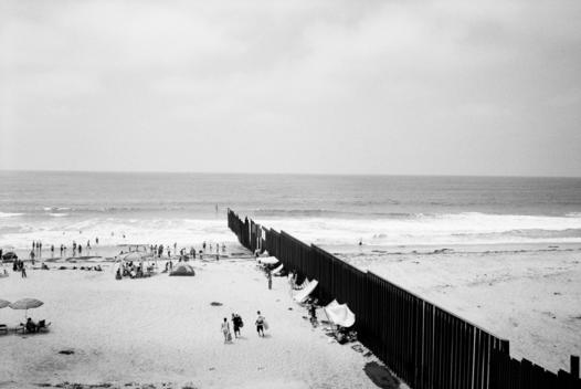 Tijuana, Mexico August 19, 2007 The Mexican US border fence dives into the sea on a beach. The beach is split in two by the barrier. The US side is only open to the public on the weekends and people come out to talk with Mexicans through the fence. The Me