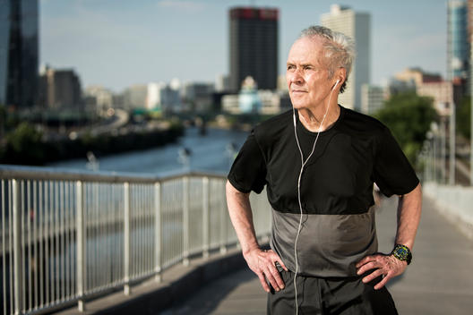 Portrait of an older 50-plus man resting after a workout, outside in an urban landscape.