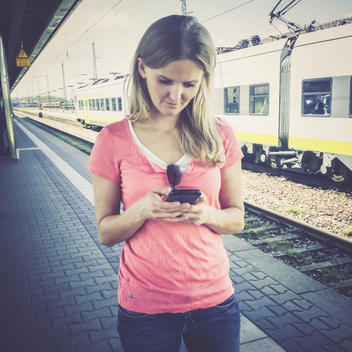 Woman with cell phone at train station