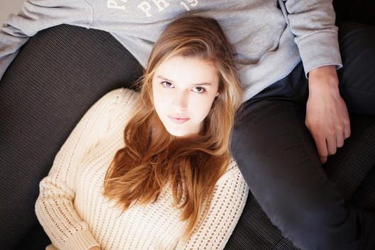 girl lying on a guy looking towards camera