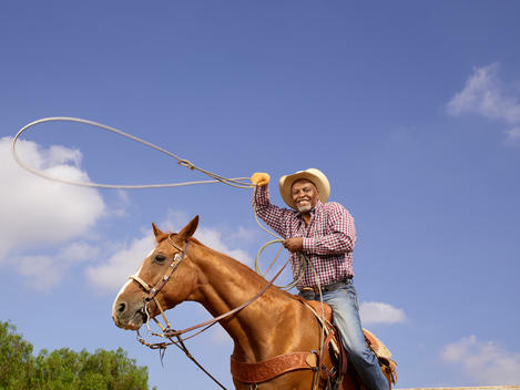 Actor James Pickens, Jr. throws a lasso as he rides his horse on a ranch