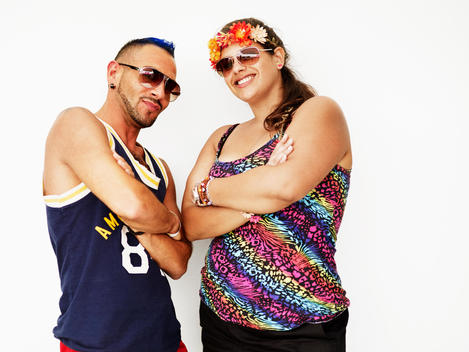 A portrait of a couple posing with their arms crossed while at an electronic dance music festival in new York