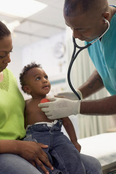 African American doctor examining baby