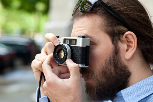 Close up of Young man focusing using old style camera