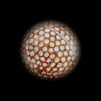 Old golf ball with dark background as a planet