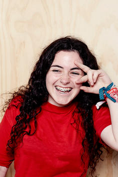 Teenage girl with brace, laughing and putting fingers in front of face