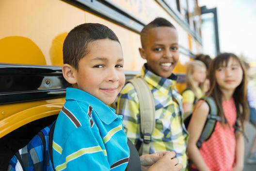 Portrait of schoolchildren standing by bus during field trip
