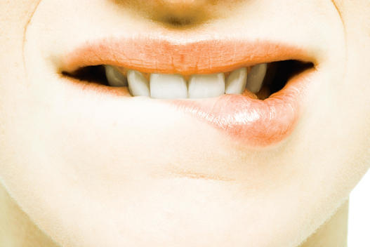 Teenage girl biting lip, extreme close-up