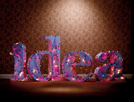 The Word Idea Covered In Fairy Lights Against A Patterned Background.