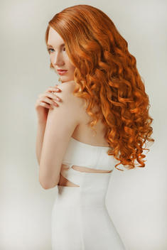 Young Woman with shiny curly red hair in profile