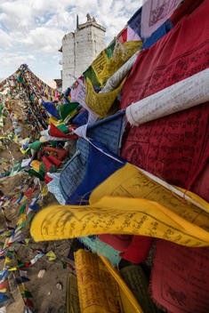 Low angle view of colorful prayer flags under hillside monastery, Leh, Ladakh, India