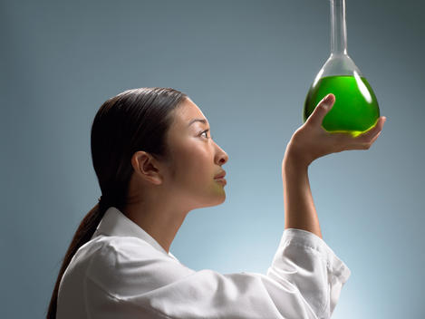 Lab Technician Examining Flask With Green Liquid