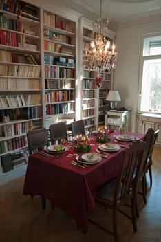 Place setting on dining table with bookshelf in background
