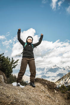 Young woman celebrating on mountain ridge, Hundsarschjoch, Vils, Bavaria, Germany