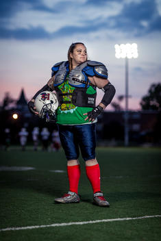 Portrait of a women's football player on the field during an evening practice.