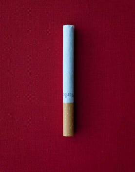 Cigarette On Red Cloth Background