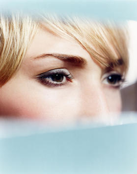 Woman Looking At Her Eye Make Up In Reflection