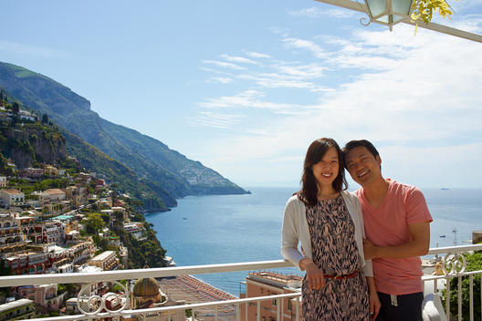 Korean couple overlooking hillside city, Positano, Campania, Italy