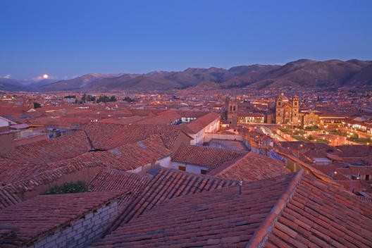 Moon Rise Over The City Of Cusco At Dusk With Red Clay Half Round Roof Tops