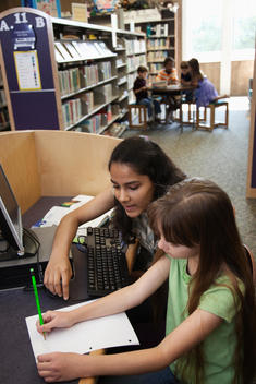 Children doing homework in library together