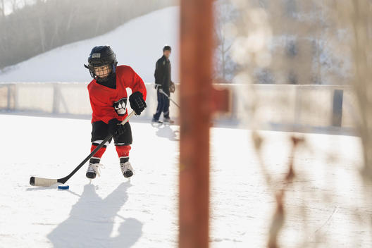 Young ice hockey player practicing on rink
