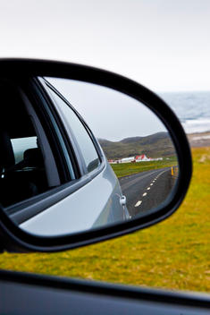 Farm Houses In West Fjords Seen Through Rear View Mirror Of Car