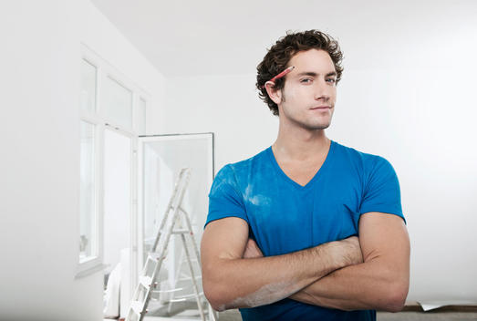 Germany, Cologne, Young man with pencil behind ear in renovating apartment, portrait