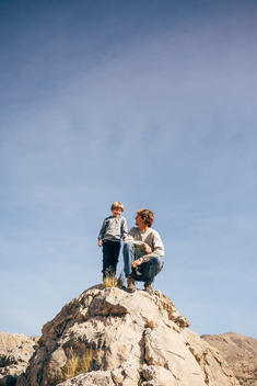 young man and 6 year old boy on rocks in desert setting in Death Valley National Park.