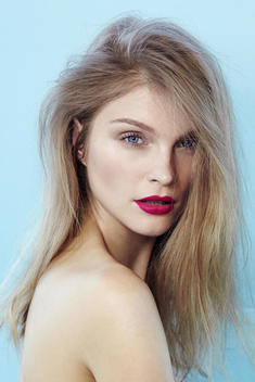 Close-up up of dark blonde model in bare skin and light natural makeup and pink lips